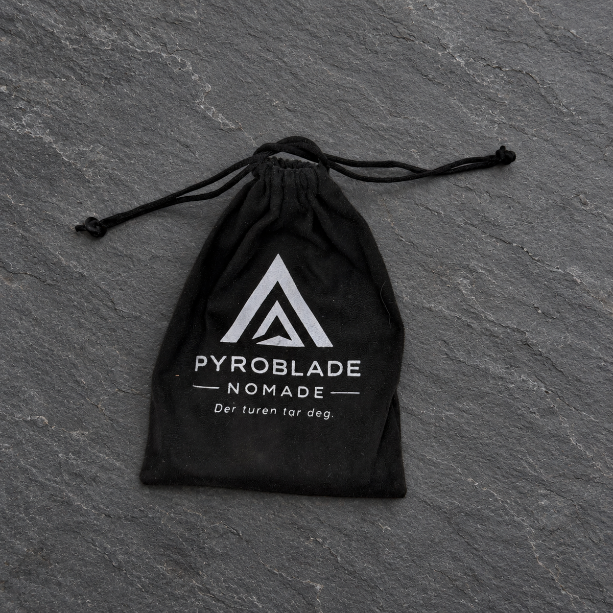 Svart oppbevaringspose til Pyroblade Nomade på mørk skifer